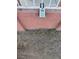 A gray lockbox hangs on the white railing outside the peach colored house at 2700 Spear St, North Las Vegas, NV 89030
