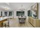 Bright dining area with modern chandelier, artwork, and view to kitchen bar and sitting area at 2817 Billy Casper Dr, Las Vegas, NV 89134