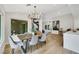 Dining room with a wood table, gray chairs, modern chandelier, and views into the living room and kitchen at 2817 Billy Casper Dr, Las Vegas, NV 89134