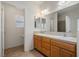 Bathroom featuring double sinks and wooden cabinets with decorative tile backsplash at 340 Domingo St, Pahrump, NV 89048