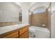 Bathroom featuring a sink, toilet and tub/shower combo with tiled walls at 340 Domingo St, Pahrump, NV 89048