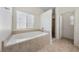 Clean bathroom featuring a soaking tub, shower, and vanity with sink, all with natural light at 340 Domingo St, Pahrump, NV 89048