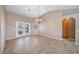 Open dining room with chandelier, tile floors, and access to backyard through double doors at 340 Domingo St, Pahrump, NV 89048