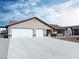 Home exterior with a spacious three-car garage and desert landscaping at 340 Domingo St, Pahrump, NV 89048