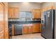 Modern kitchen featuring wooden cabinets, stainless steel appliances, and a tile backsplash at 340 Domingo St, Pahrump, NV 89048