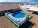 Above-ground pool with deck and slide set against the backdrop of a desert landscape and mountains at 340 Domingo St, Pahrump, NV 89048