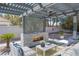 A covered outdoor patio area with a fireplace and comfortable seating, perfect for relaxation and entertainment at 3465 Pama Ln, Las Vegas, NV 89120