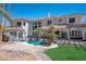 Expansive rear exterior showcasing the pool, rock features, patio, and a well-maintained landscape at 3465 Pama Ln, Las Vegas, NV 89120