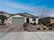 Inviting single-story home with brick driveway, manicured landscaping, and a two-car garage at 3726 Shaving Shadows Ave, North Las Vegas, NV 89032