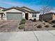 Inviting home with a green garage door, brick steps, and drought-resistant landscaping at 3726 Shaving Shadows Ave, North Las Vegas, NV 89032