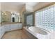 Bathroom with a soaking tub, walk-in shower, and vanity with drawers and a large mirror at 380 Claremont St, Boulder City, NV 89005