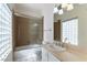 This tiled bathroom features a shower-tub combination with sliding doors and vanity with decorative lighting at 380 Claremont St, Boulder City, NV 89005