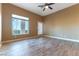 This bedroom features neutral colors, a wood-look floor, a ceiling fan and plenty of natural light at 380 Claremont St, Boulder City, NV 89005