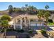 Stately home with a tile roof, palm trees, and a three-car garage on a sunny day at 380 Claremont St, Boulder City, NV 89005