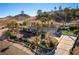 Elevated view of a beautiful home with a tile roof, three-car garage, mature trees, and desert landscaping at 380 Claremont St, Boulder City, NV 89005