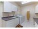 Functional laundry room with white cabinets, a sink, and modern appliances at 380 Claremont St, Boulder City, NV 89005