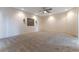 Spacious living room with neutral carpet, ceiling fan, and elegant wall sconces at 380 Claremont St, Boulder City, NV 89005