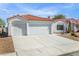 Single-story home featuring a well-maintained front yard with an attached two-car garage and a large driveway at 4032 Bola Dr, North Las Vegas, NV 89032