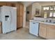 Well-lit kitchen featuring white appliances, tile flooring and light wood cabinets at 4032 Bola Dr, North Las Vegas, NV 89032