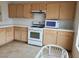 Functional kitchen featuring tile countertops, wood cabinetry, and essential appliances for everyday cooking at 4032 Bola Dr, North Las Vegas, NV 89032