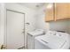 Laundry area featuring a washer, dryer, storage cabinet and convenient access door at 4032 Bola Dr, North Las Vegas, NV 89032