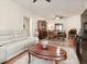 Spacious living room with white sofa, dark wood accents, and access to dining area at 4615 Puglia Ln # 201, North Las Vegas, NV 89084