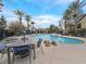 Inviting outdoor swimming pool surrounded by palm trees and lounge chairs for relaxation and enjoyment at 4615 Puglia Ln # 201, North Las Vegas, NV 89084