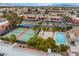 Aerial view of community pool and tennis courts with surrounding residential buildings and mountains in the distance at 5097 Indian River Dr # 172, Las Vegas, NV 89103