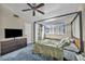 Spacious bedroom with a four-poster bed, large window, and TV, creating a comfortable living space at 5157 Garden Ln # F, Las Vegas, NV 89119
