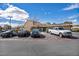 A paved parking lot with multiple parked cars outside a neighborhood with mature trees at 5157 Garden Ln # F, Las Vegas, NV 89119