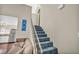 Carpeted staircase leading to the upper level, with a partial view of the living area and kitchen at 5157 Garden Ln # F, Las Vegas, NV 89119