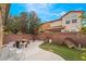 Well maintained backyard featuring artificial grass, a brick wall, a stone table, and a water fountain at 6177 W Cougar Ave, Las Vegas, NV 89139
