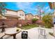Spacious backyard featuring artificial grass, a brick wall, a table set, and well maintained landscaping at 6177 W Cougar Ave, Las Vegas, NV 89139