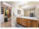 Bright bathroom featuring a wide vanity, a large mirror, and tile flooring at 6177 W Cougar Ave, Las Vegas, NV 89139