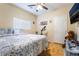 Neutral bedroom with a comfy bed, ceiling fan, mounted TV, and tile flooring at 6177 W Cougar Ave, Las Vegas, NV 89139