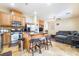 Open-concept kitchen with a granite island, wooden cabinets and stainless steel appliances flowing to the living room at 6177 W Cougar Ave, Las Vegas, NV 89139