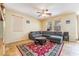 Bright living room featuring a ceiling fan, large sectional sofa, and a patterned area rug at 6177 W Cougar Ave, Las Vegas, NV 89139