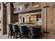 Luxurious bar area featuring a countertop with seating and rustic wood cabinetry at 64 Promontory Ridge Dr, Las Vegas, NV 89135