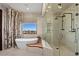 This bright bathroom has a soaking tub and a glass shower with dual shower heads at 64 Promontory Ridge Dr, Las Vegas, NV 89135