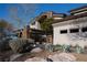 Beautiful exterior elevation featuring desert landscaping, stacked stone accents, and porte cochere at 64 Promontory Ridge Dr, Las Vegas, NV 89135