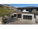 Exterior view of a modern home featuring three-car garage with mountain views at 64 Promontory Ridge Dr, Las Vegas, NV 89135
