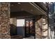 Close-up of the stone front door with wood and iron accents and recessed lighting above at 64 Promontory Ridge Dr, Las Vegas, NV 89135