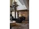 Open living room featuring a grand chandelier, stone pillars, and black leather seating at 64 Promontory Ridge Dr, Las Vegas, NV 89135
