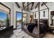 This grand bedroom features a four-poster bed, beamed ceilings, and an outdoor view with pool access at 64 Promontory Ridge Dr, Las Vegas, NV 89135