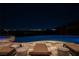 Stunning pool area at night with city views and comfortable lounge seating at 64 Promontory Ridge Dr, Las Vegas, NV 89135