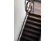 Close-up view of a dark wooden staircase with a metal railing and decorative lighting at 64 Promontory Ridge Dr, Las Vegas, NV 89135