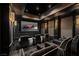 Home theater showcasing a large screen, tiered seating, and elegant sconces for the ultimate viewing experience at 64 Promontory Ridge Dr, Las Vegas, NV 89135