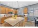 Bright kitchen features a large island, granite countertops, stainless steel appliances and wood cabinetry at 7232 Frontier Hills Ave, Las Vegas, NV 89113