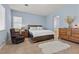 Spacious main bedroom with large bed, wood furnishings and plenty of light at 7232 Frontier Hills Ave, Las Vegas, NV 89113