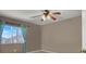 Bedroom with light-colored walls, ceiling fan, and view to the outside at 7416 Tuckaway Harbor St, Las Vegas, NV 89139